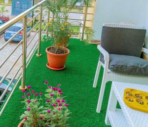 a balcony with a chair and flowers on the floor at Integral Consults Apartment in Abuja