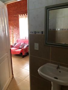 a bathroom with a sink and a bed in a room at Casa Ama in Puerto Iguazú