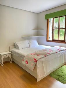 um quarto com uma cama e uma janela em Apartamento Lago Negro em Gramado