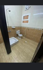 a bathroom with a toilet and a bath tub at أجنحة مارينا طيبة in Al Madinah