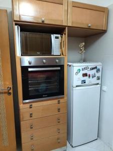 a kitchen with a microwave oven and a refrigerator at Cosy appartement à proximité de l'aéroport de salé et technopolis in Oulad Yakoub