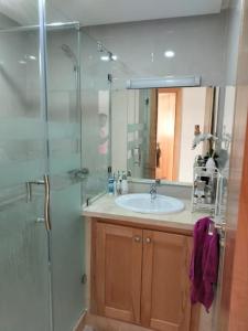 a bathroom with a sink and a glass shower at Cosy appartement à proximité de l'aéroport de salé et technopolis in Oulad Yakoub