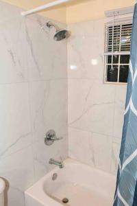biała łazienka z prysznicem i umywalką w obiekcie Simply Cassine w mieście Falmouth