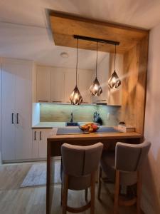 a kitchen with a table with chairs and lights at Vila Jahor - Apartmani Trifković in Jahorina