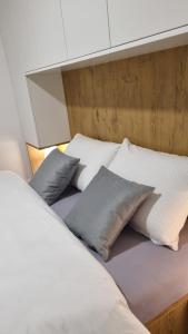 łóżko z poduszkami w pokoju w obiekcie Vila Jahor - Apartmani Trifković w mieście Jahorina