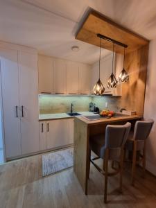 a kitchen with white cabinets and a table and chairs at Vila Jahor - Apartmani Trifković in Jahorina