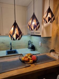 a bowl of fruit on a kitchen counter with lights at Vila Jahor - Apartmani Trifković in Jahorina