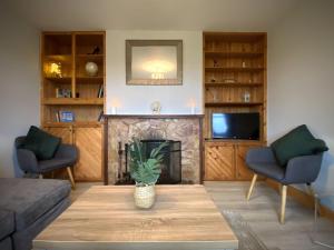 ein Wohnzimmer mit einem Tisch und einem Kamin in der Unterkunft Cottage 427 - Clifden in Clifden