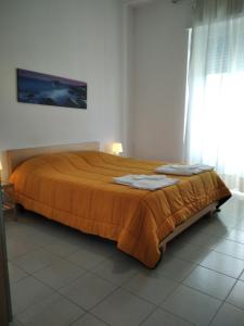 ペスカーラにあるAdriaticaのベッドルーム1室(大型ベッド1台、オレンジ色のベッドカバー付)