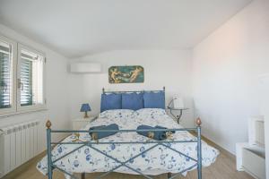 a bedroom with a bed with blue pillows at Casa Valastro in Aci Castello