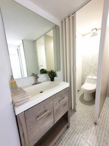 a bathroom with a sink and a toilet and a mirror at Habitación para 8 personas en Polanco Literas in Mexico City