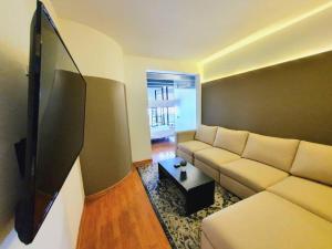 sala de estar con sofá blanco y TV en Habitación para 8 personas en Polanco Literas, en Ciudad de México