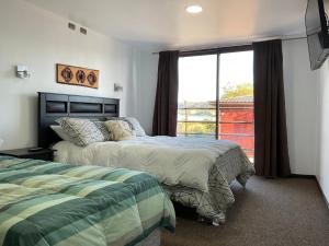 a bedroom with two beds and a large window at Hostal Umantun in Dalcahue