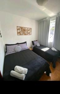 1 dormitorio con 2 camas y ventana en Ap da Lú en Teresópolis