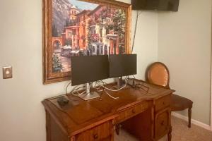 a desk with a computer monitor on top of it at Lake Keowee Resort Condo with Balcony and Pool Access! in Salem