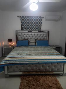 um quarto com uma cama com almofadas azuis e um azul em RESIDENCIAL PARADISE 3 J3 em Santiago de los Caballeros