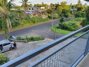 a man standing next to a white van on a street at Family Homestay with 3 Bedrooms in Suva