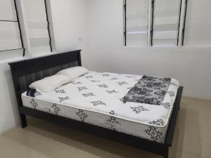 a small bed in a bedroom with a white and black blanket at Family Homestay with 3 Bedrooms in Suva
