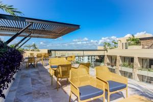 un patio con mesas y sillas amarillas en un edificio en Syrena 503 en Playa del Carmen