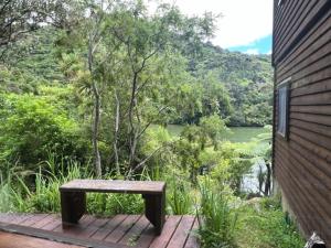 eine Bank auf einer Holzterrasse neben einem Fluss in der Unterkunft Waterfall Bay in Broughton Bay + 3 Fotos