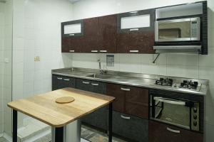 a kitchen with a wooden table and a microwave at Next Door in Bogotá
