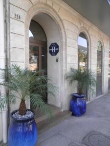 
a blue vase sitting on top of a sidewalk next to a building at Au Nouvel Hôtel in Toulon
