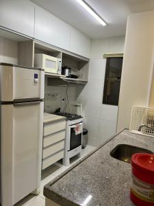 a kitchen with a white refrigerator and a stove at Apartamento Cumbuco, c2 307 in Caucaia