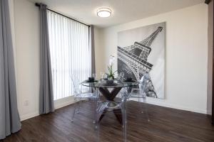 a dining room with a table and a picture of the eiffel tower at Prime Location 1-Bedroom with Balcony and Pool in Los Angeles