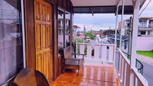 a porch with a wooden door and a chair on a balcony at Alpha Arenal in Fortuna