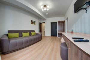 a living room with a couch and a television at Dolyna Gir in Bukovel