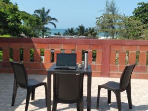 een laptop op een tafel met twee stoelen bij Hostal Casa Taisha in Montañita