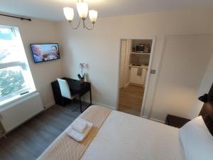 a bedroom with a bed and a desk and a window at Mill View Apartment - Self contained one bed apartment in Oxford