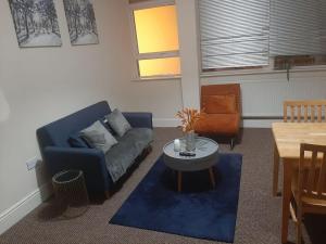 uma sala de estar com um sofá azul e uma mesa em Spacious. Contractors. Brierley em Brierley Hill