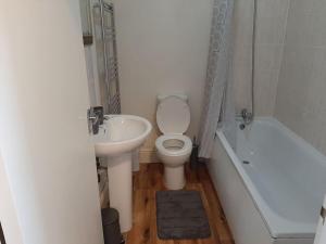 uma casa de banho com um lavatório, um WC e uma banheira em Spacious. Contractors. Brierley em Brierley Hill