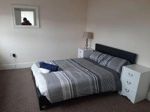 1 dormitorio con cama y espejo. en Spacious. Contractors. Brierley, en Brierley Hill