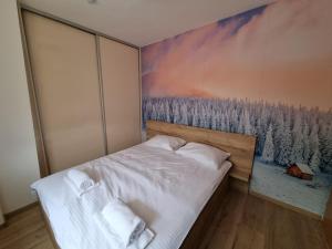 a bedroom with a painting on the wall at Apartmani Aspen in Jahorina