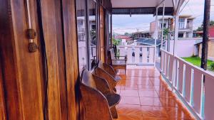 a balcony with chairs sitting on a porch at Alpha Arenal in Fortuna