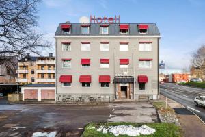 a hotel building with red awnings on a street at Best Western Sjofartshotellet in Oskarshamn