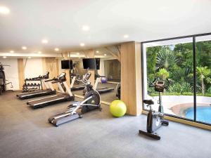 a gym with exercise equipment and a swimming pool at Ibis Styles Bogor Raya in Bogor