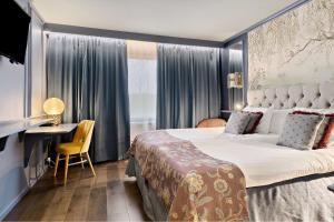 カールスハムンにあるBest Western Karlshamn Spa & Relaxの大きなベッドとデスクが備わるホテルルームです。