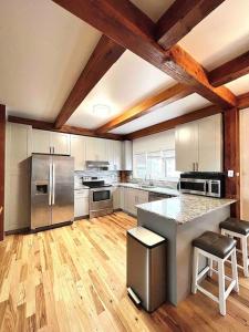 a large kitchen with stainless steel appliances and wooden floors at NEW Bijou Bayside Escape- 3beds, Balcony, Deck, Dock in Ocean City