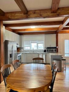 a large kitchen with a wooden table and chairs at NEW Bijou Bayside Escape- 3beds, Balcony, Deck, Dock in Ocean City