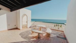 balcón con mesa, bancos y el océano en Palmas 14b en Puerto Peñasco