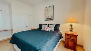 1 dormitorio con 1 cama azul y 1 lámpara en Palmas 14b en Puerto Peñasco