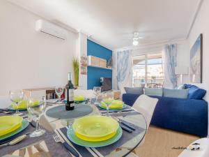 uma sala de jantar com uma mesa com pratos amarelos e copos de vinho em Atico Apartament Rose em Mar de Cristal