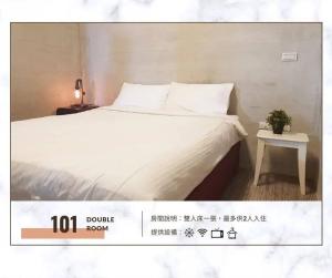 a bedroom with a white bed and a table at Han's inn in Magong