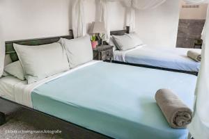 1 dormitorio con 2 camas y sofá en Lost in San Jose Hostel & Suites, en San José