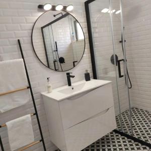 La salle de bains blanche est pourvue d'un lavabo et d'un miroir. dans l'établissement RIVERINN Casa Familiar T 3 c Acesso Terraço 1 andar, à Portimão