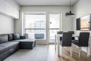 ein Wohnzimmer mit einem Sofa und einem Tisch mit Stühlen in der Unterkunft Turun Blanka A14 in Turku