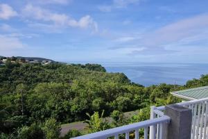 a view of the ocean from the balcony of a house at The Den & Deck in Anse La Raye